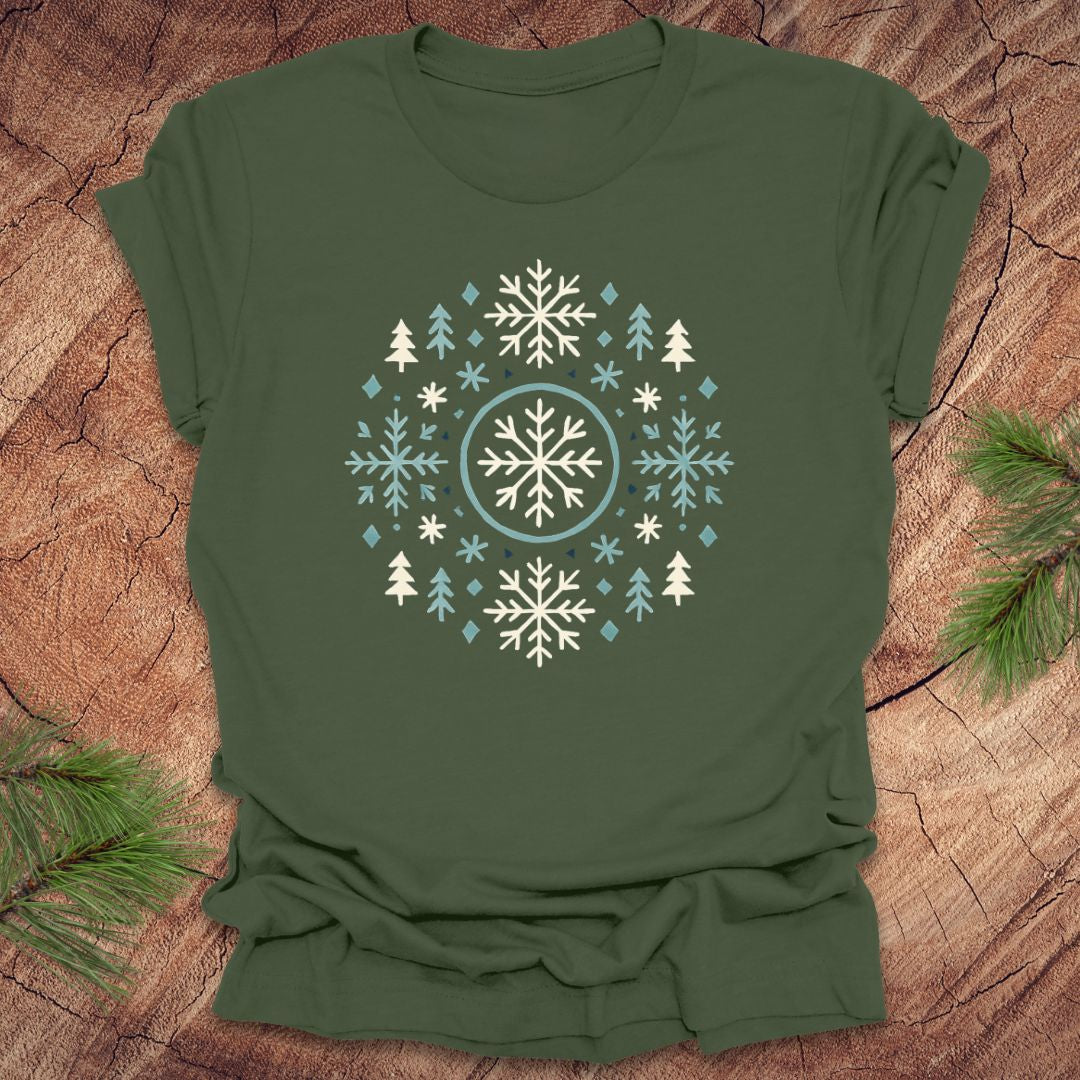 Green t-shirt with snowflake and tree design on a wooden surface