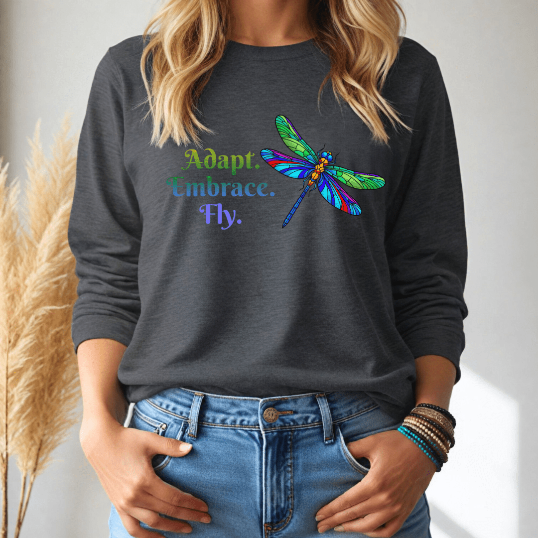 Person wearing a dark gray long-sleeve tshirt with a colorful dragonfly design and text.