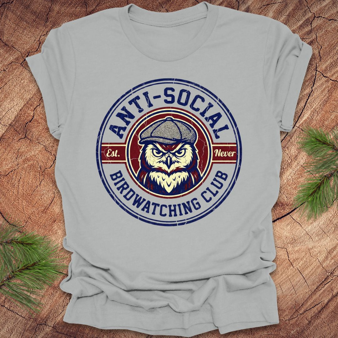 Gray t-shirt with 'Anti-Social Birdwatching Club' owl graphic on a wooden surface