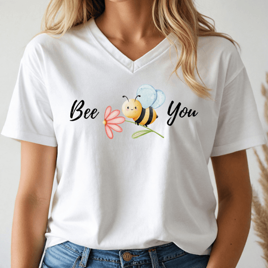 White v-neck tshirt with a cute bee and the text, "Bee You" worn by a woman.