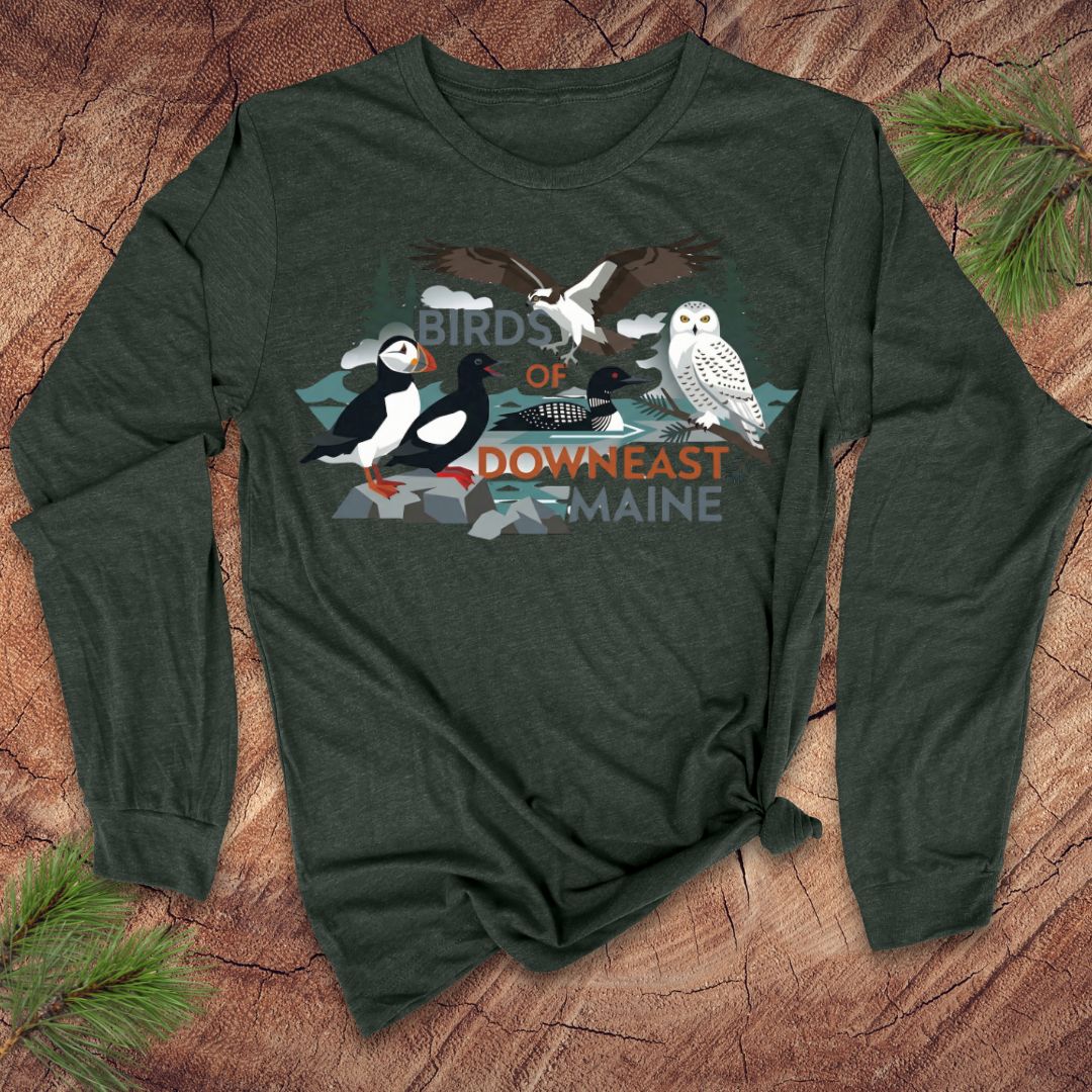 Green long-sleeve shirt with bird graphic and 'Birds of Downeast Maine' text on a wooden surface.