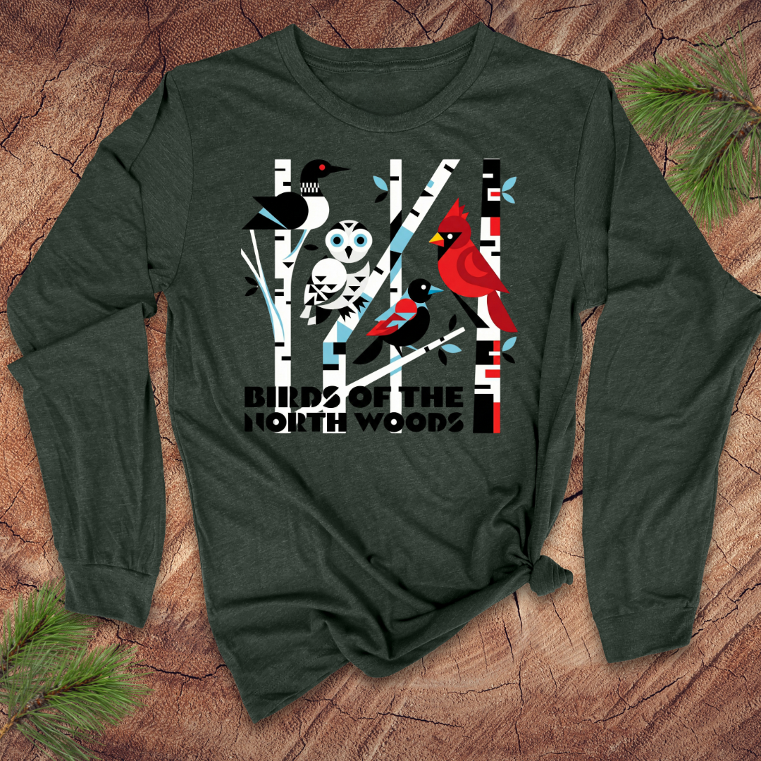 Green long-sleeve shirt with 'Birds of the North Woods' design on a wooden surface.