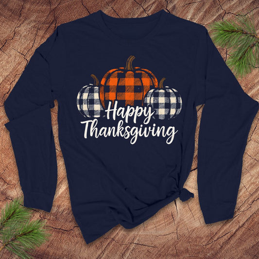 Navy blue long-sleeve tshirt with 'Happy Thanksgiving' text and plaid pumpkins on a wooden surface.