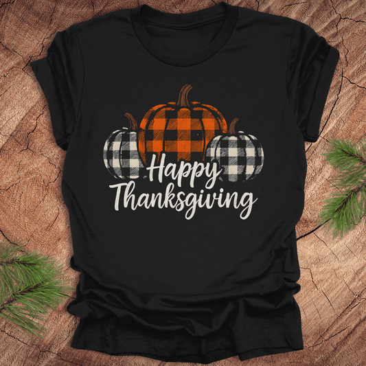 Black t-shirt with 'Happy Thanksgiving' and checkered pumpkins design on a wooden surface.