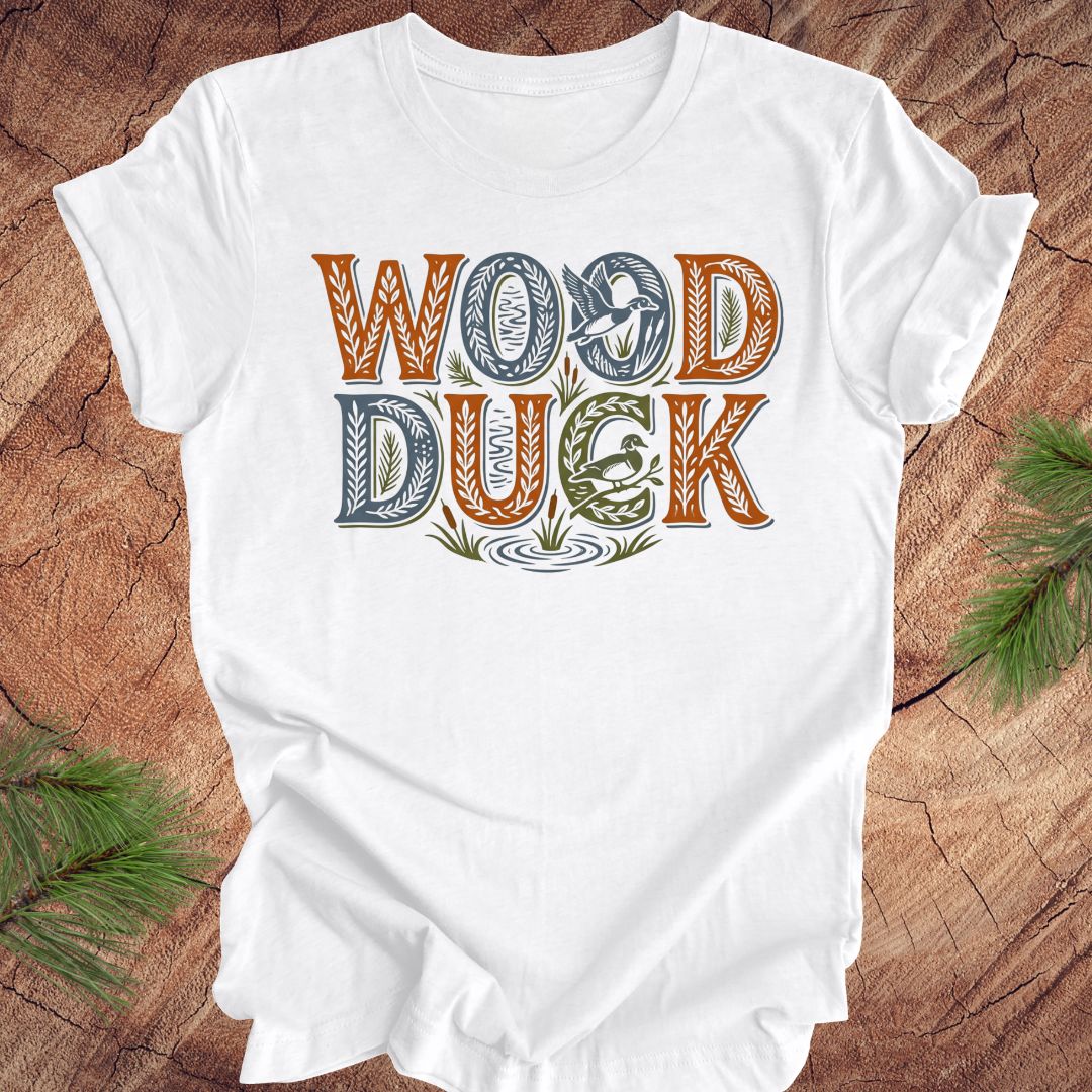 White t-shirt with 'Wood Duck' text on a wooden surface
