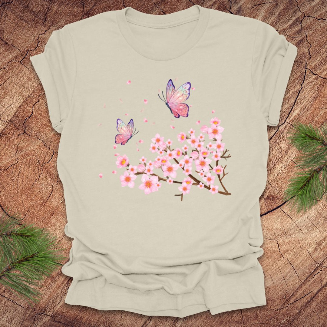Beige t-shirt with butterfly and cherry blossom design on a wooden surface