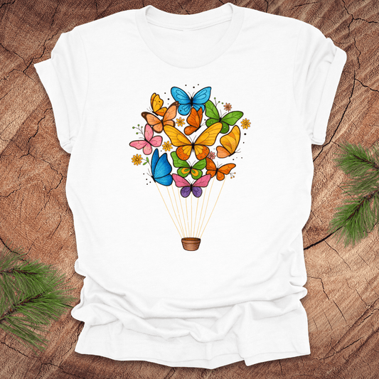 White t-shirt with colorful butterfly design on a wooden surface