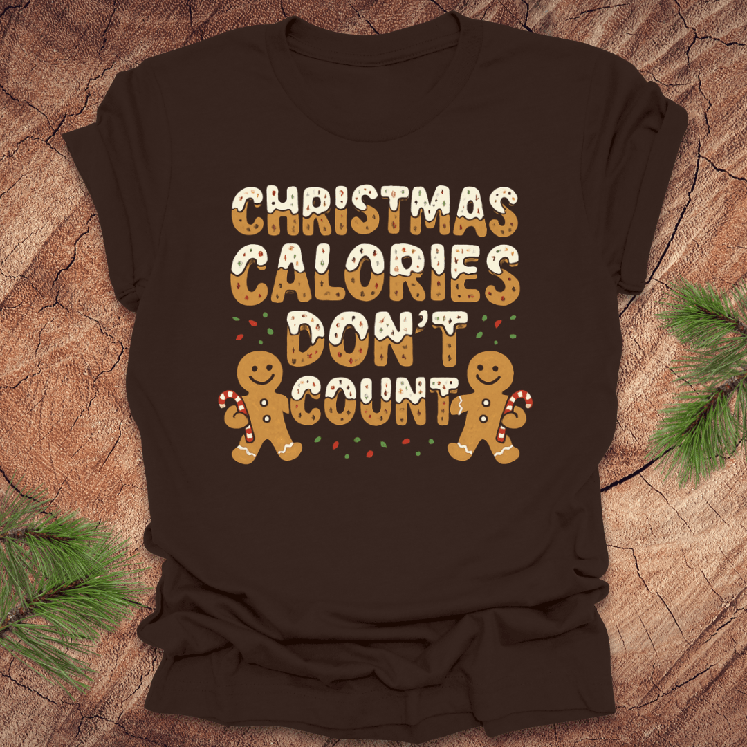 Brown tshirt with festive gingerbread text, 'Christmas calories don't count' with gingerbread men on a wooden background.
