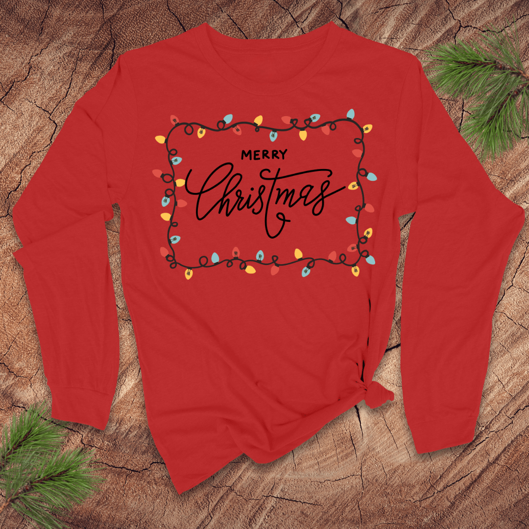 Red long-sleeve shirt with 'Merry Christmas' text and lights on a wooden surface.