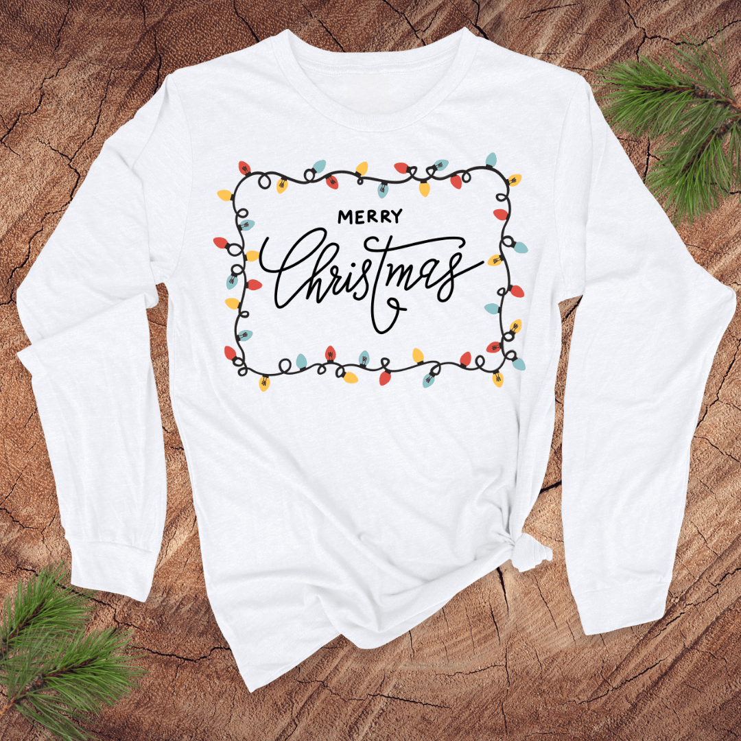 White long-sleeve shirt with 'Merry Christmas' design on a wooden surface