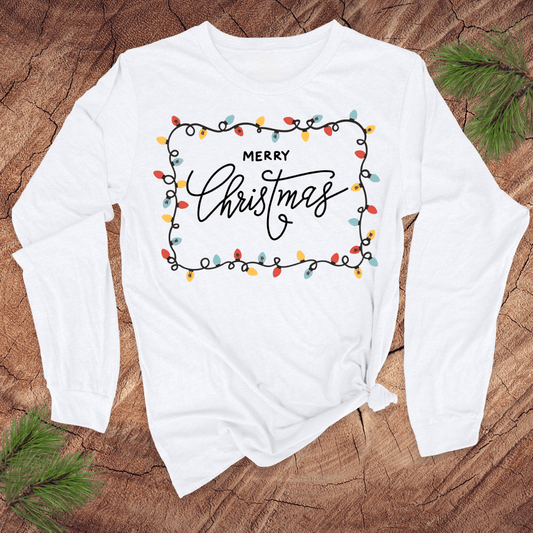 White long-sleeve shirt with 'Merry Christmas' design on a wooden surface