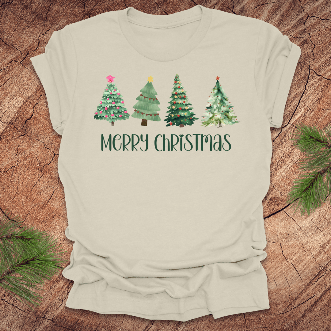 Beige tshirt with the text 'Merry Christmas' and christmas trees on a wood background.