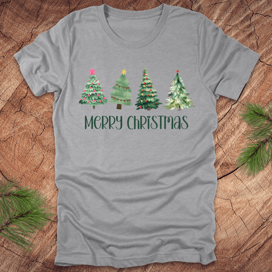 Grey tshirt with the text 'Merry Christmas' and christmas trees on a wood background.