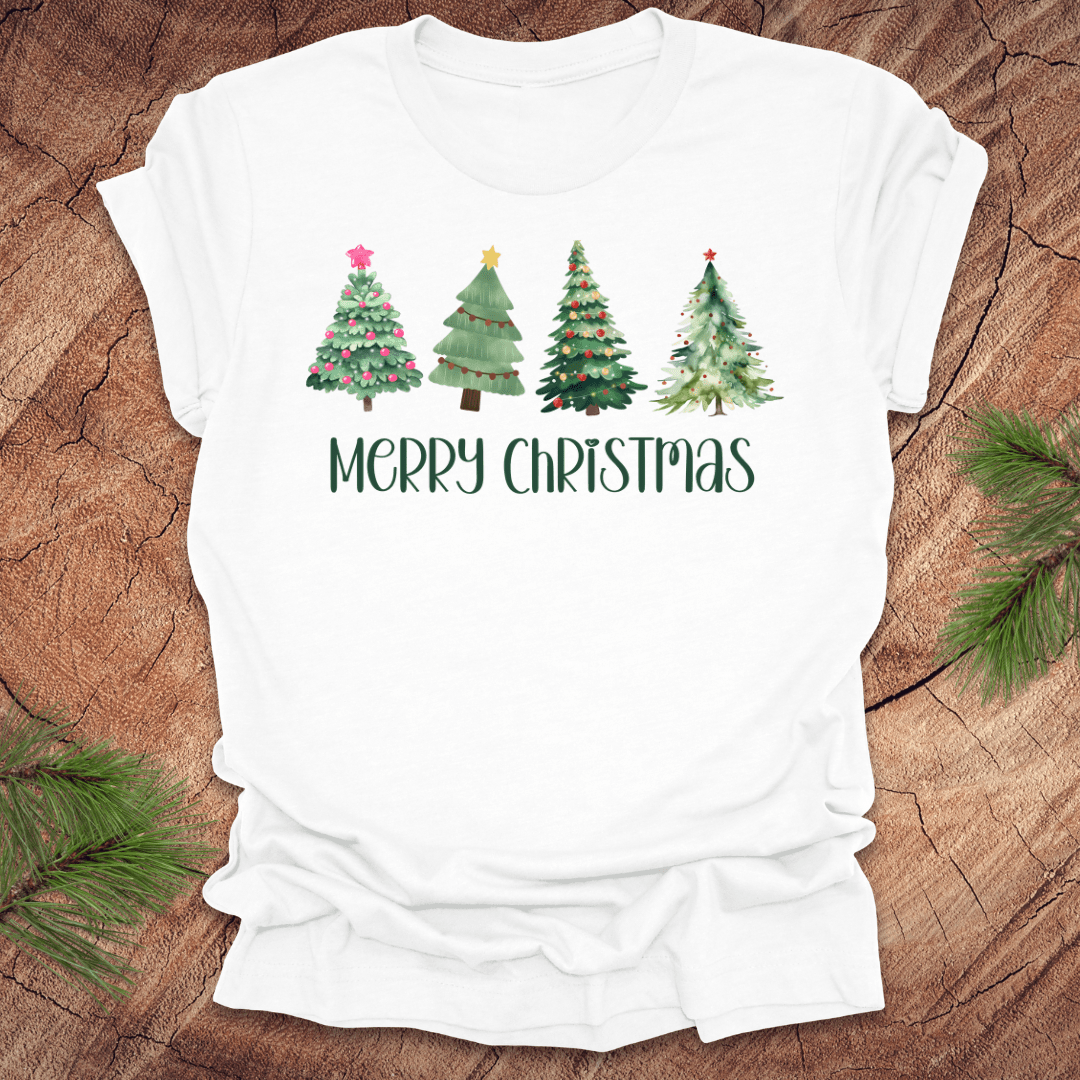 White tshirt with the text 'Merry Christmas' and christmas trees on a wood background.
