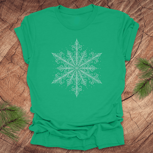 Green t-shirt with a white snowflake design on a wooden surface