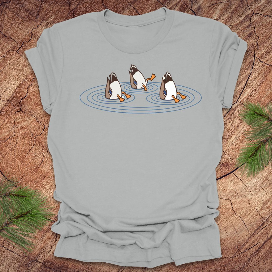 Silver t-shirt with cartoon ducks dabbling on a pond design on a wooden surface