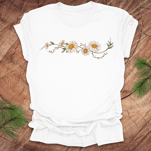 White t-shirt with daisy design on a wooden surface