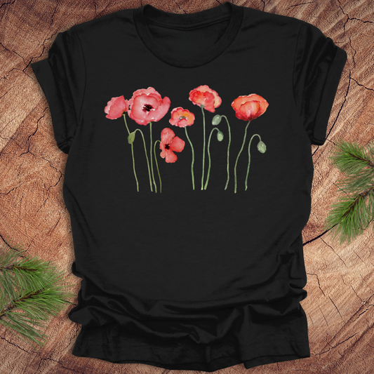 Black t-shirt with red poppy design on a wooden surface