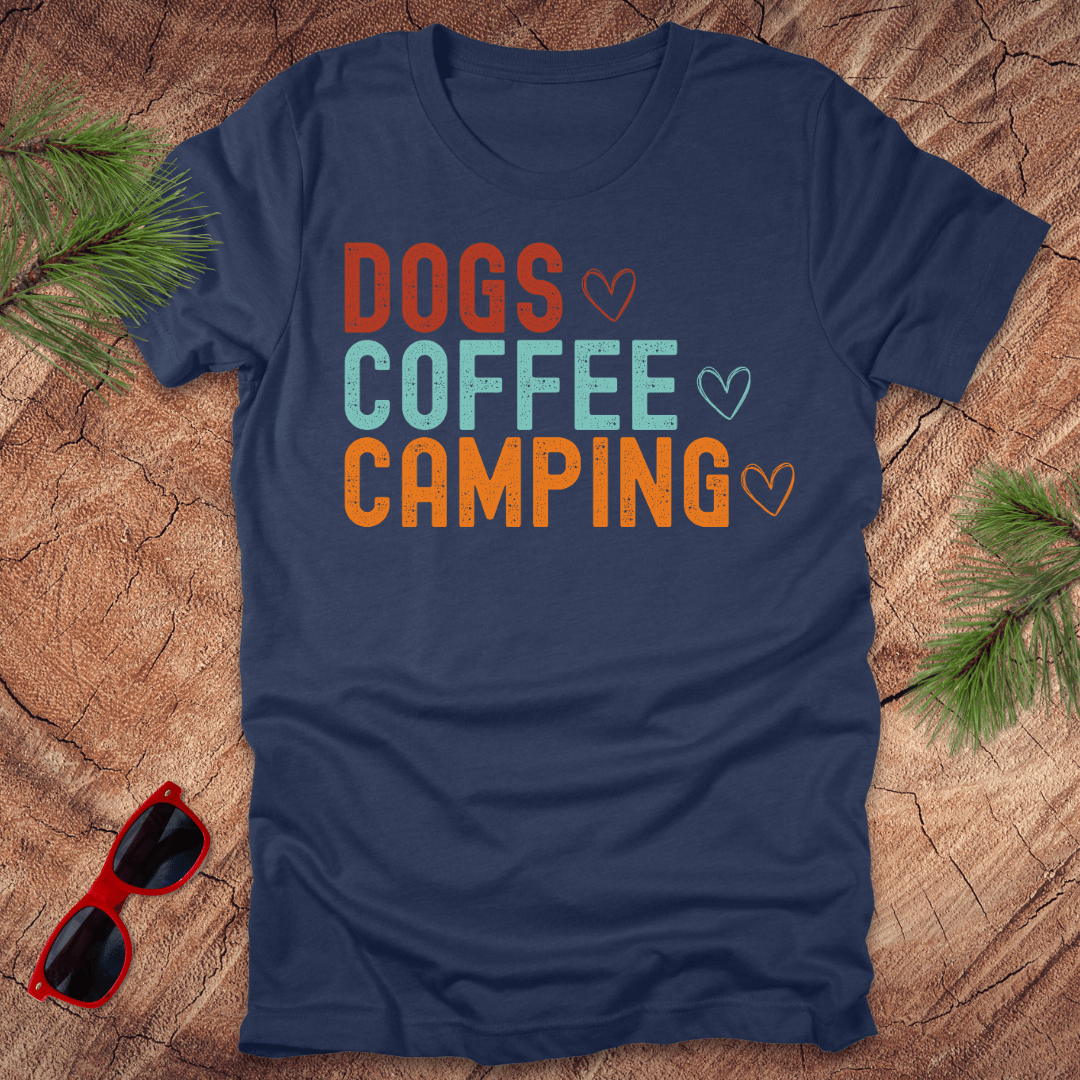 Blue t-shirt with text, Dogs, Coffee, Camping on a wood background with sunglasses.
