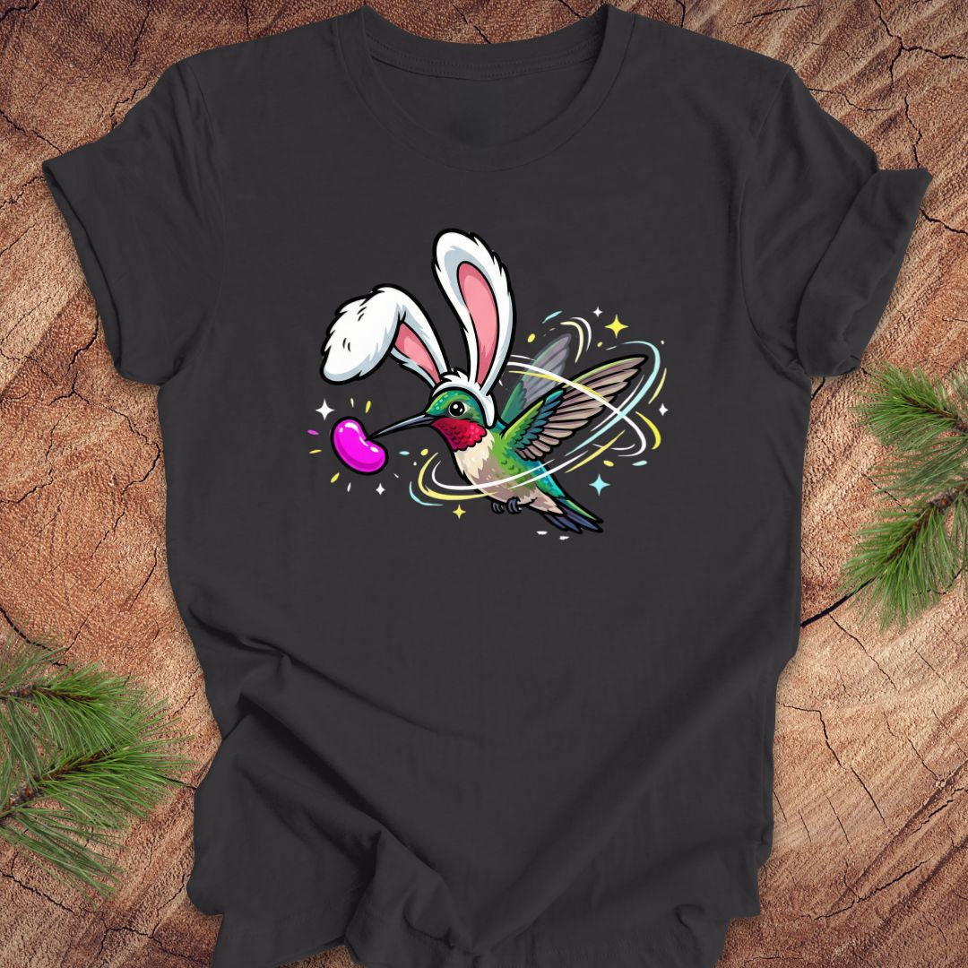 Dark gray t-shirt with a colorful design of a hummingbird with bunny ears on a wooden surface.