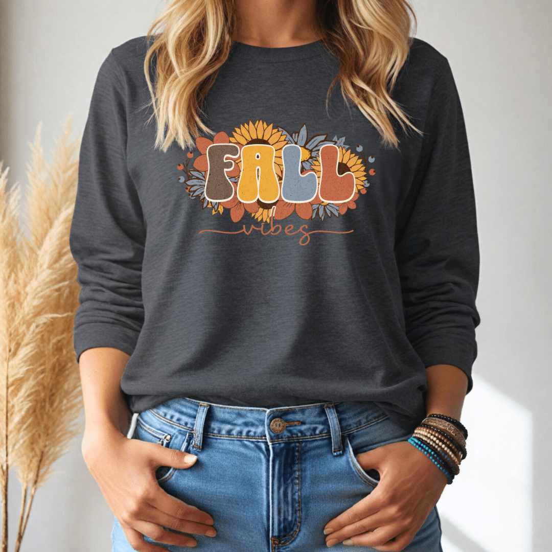 Person wearing a dark gray long sleeve shirt with 'Fall Vibes' text and sunflower design, standing against a neutral background.