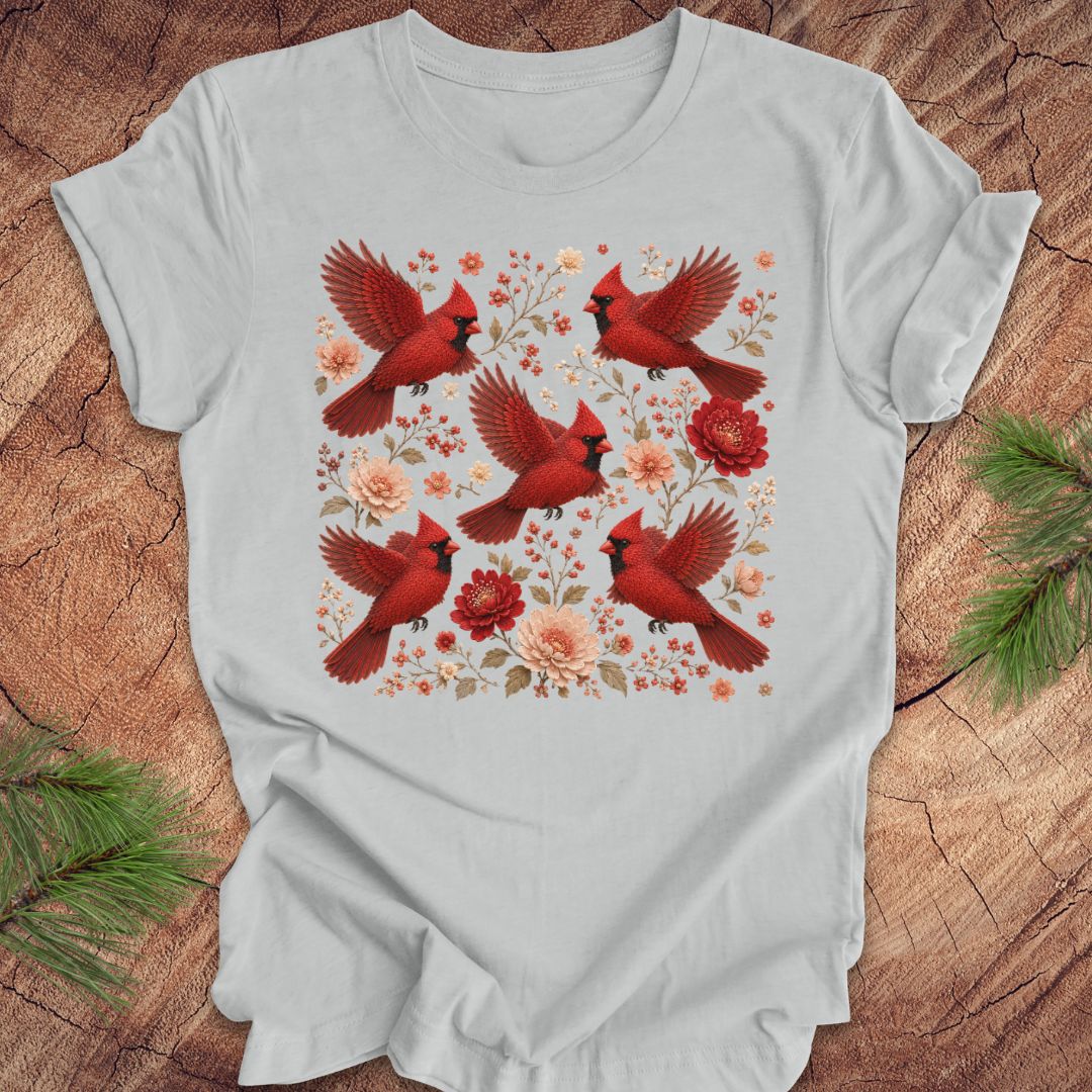 Gray t-shirt with cardinals and flowers on a wood background.