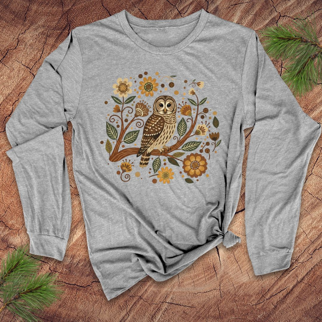 Gray long-sleeve shirt with an owl and floral design on a wooden surface