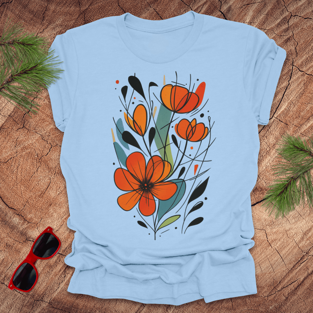 baby blue t-shirt with orange floral design on a wooden surface with sunglasses and greenery.