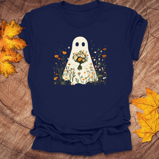 Navy blue t-shirt with a ghost holding flowers design on a wooden surface with autumn leaves.