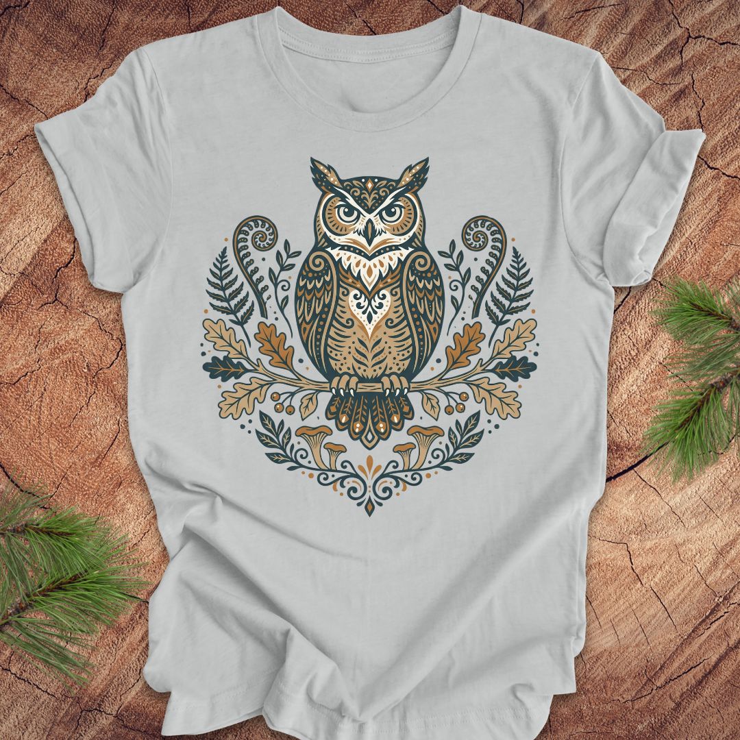 Gray t-shirt with an owl and woodland design on a wooden surface