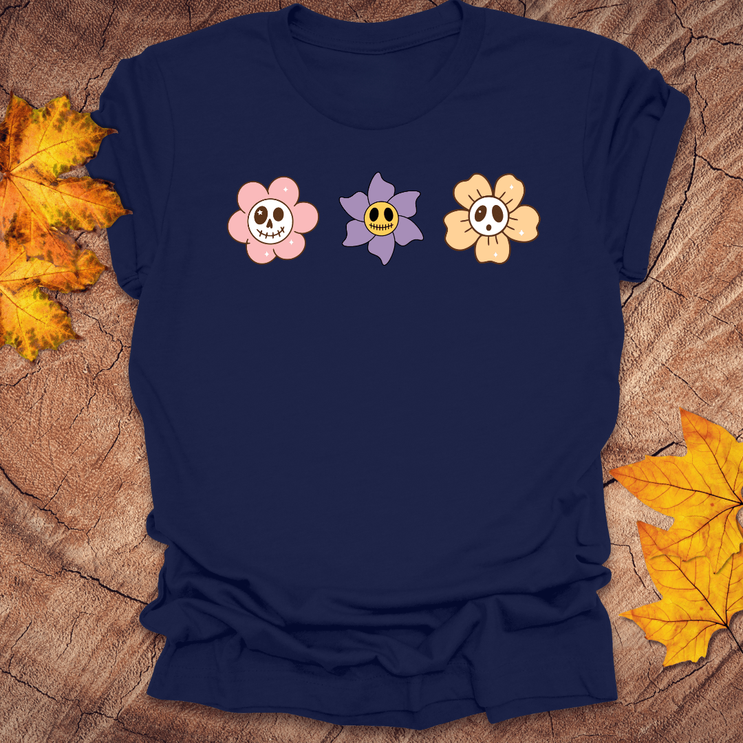 Navy blue t-shirt with cartoon flower designs on a wooden surface with autumn leaves.