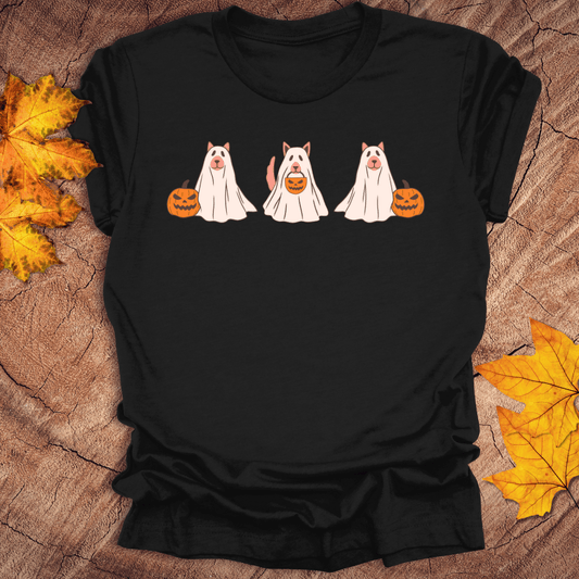A black t-shirt with Halloween-themed design of dogs dressed as ghosts and pumpkins on a wooden surface with fall leaves.