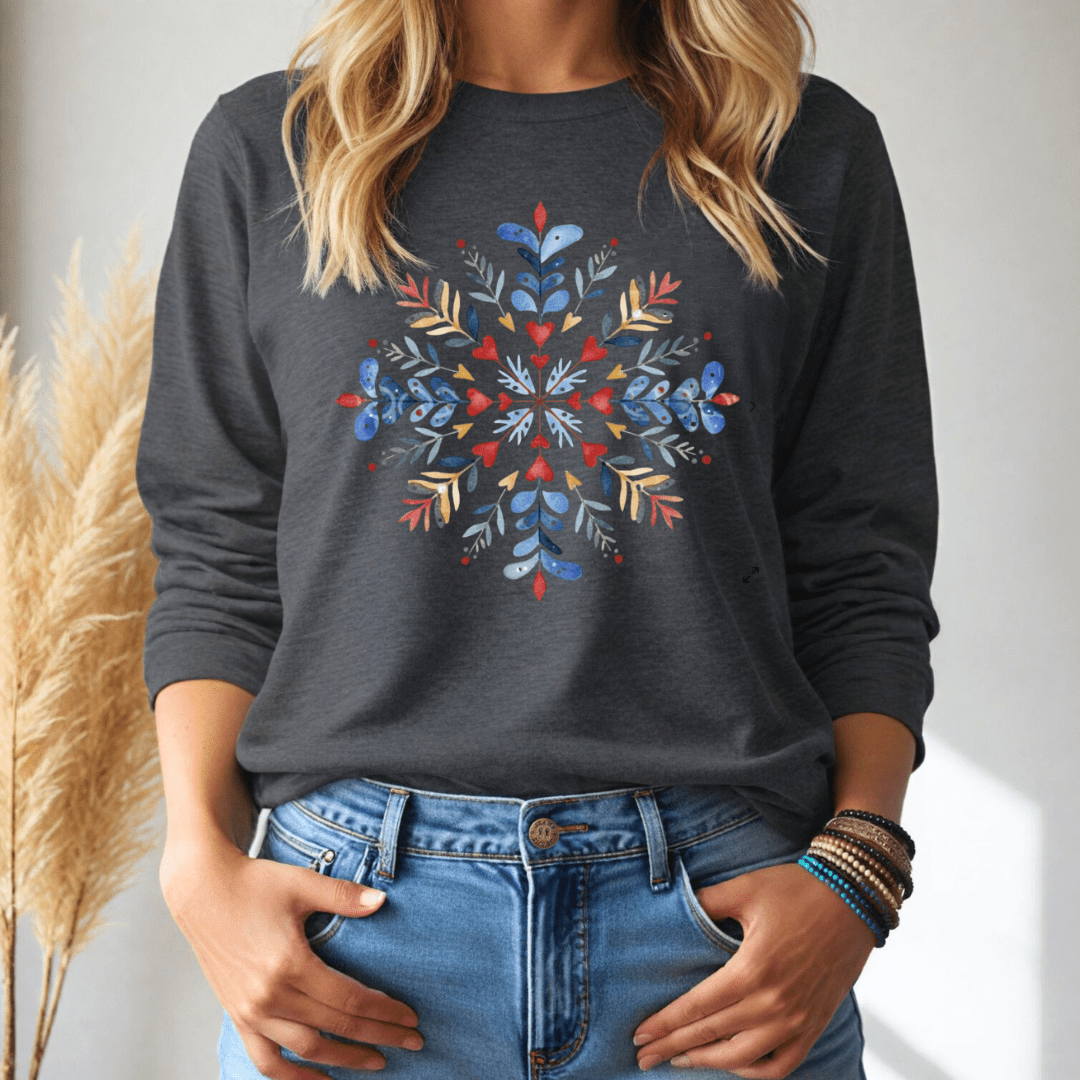 Person wearing a dark gray long sleeve shirt with a colorful floral snowflake design, standing against a neutral background.