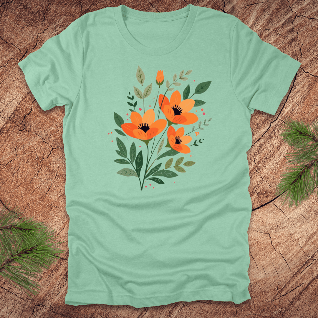 Light green t-shirt with orange floral design on a wooden surface