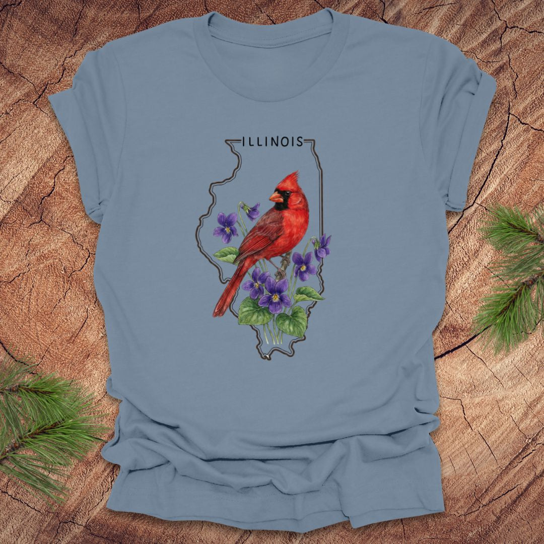Steel blue t-shirt with Illinois state outline and state bird and flower cardinal and violets design on a wooden surface