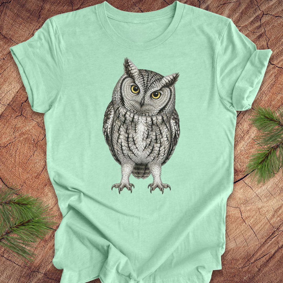 Mint green t-shirt with an owl design on a wooden surface
