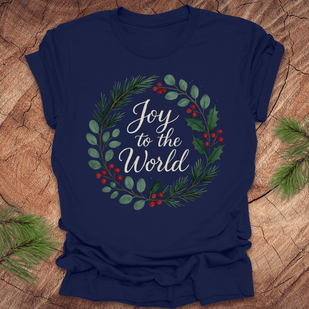 Navy blue t-shirt with wreath and text, 'Joy to the World' design on a wooden surface