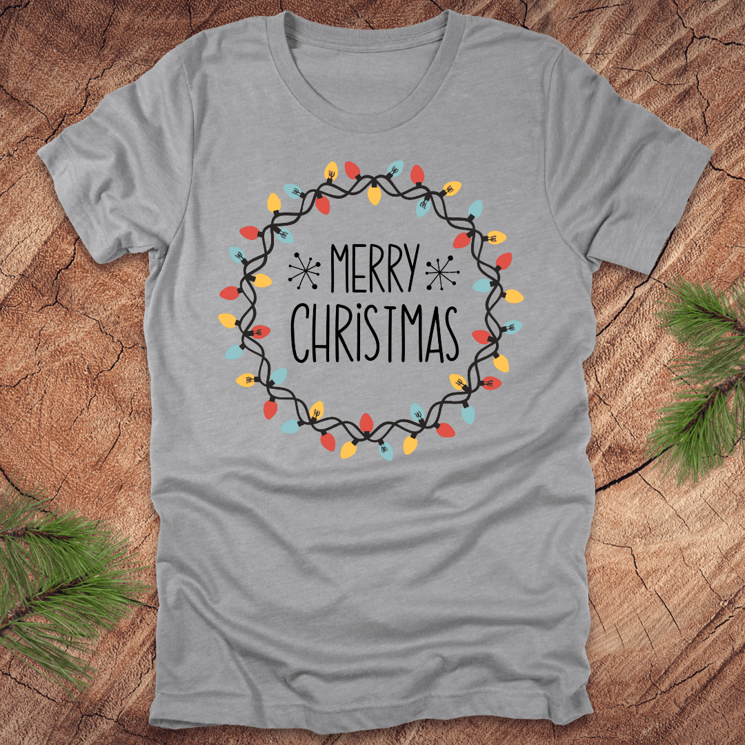 Gray t-shirt with 'Merry Christmas' design on a wooden surface