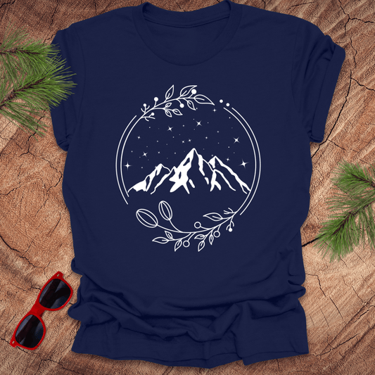 navy t-shirt with a graphic of a serene mountain scene surrounded by a circular frame, with stars and foliage accents.