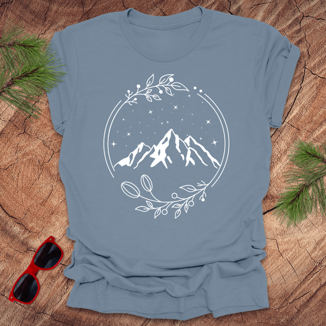 steel blue t-shirt with a graphic of a serene mountain scene surrounded by a circular frame, with stars and foliage accents.