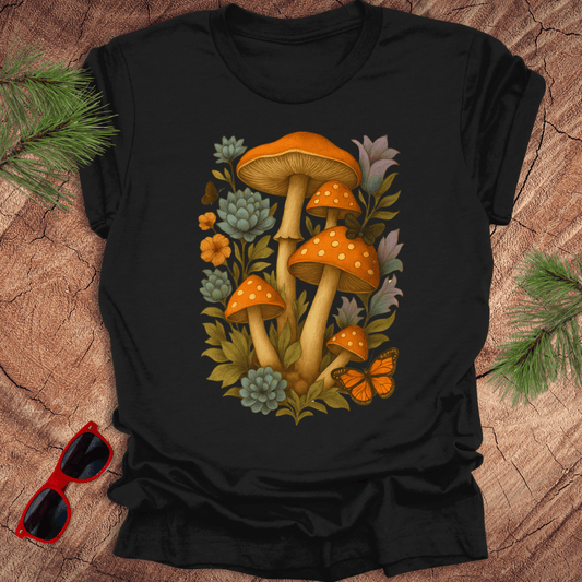 Black t-shirt with mushroom design on a wooden surface with sunglasses and leaves.