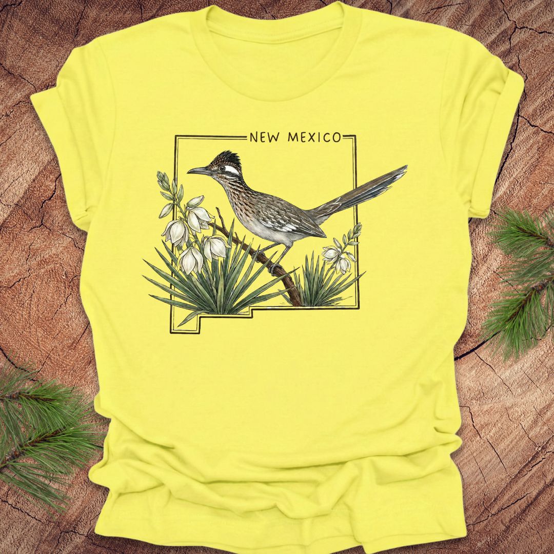 Yellow t-shirt with a roadrunner and New Mexico design on a wooden surface