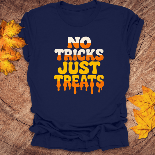 Navy blue t-shirt with 'No Tricks Just Treats' text on a wooden surface with fall leaves.
