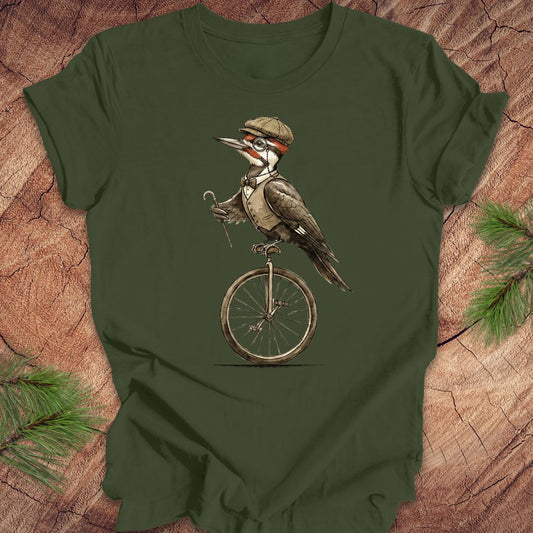 Green t-shirt with a woodpecker on a unicycle design on a wooden surface