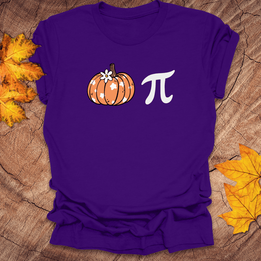 Purple t-shirt with a pumpkin and pi symbol on a wooden surface with fall leaves.