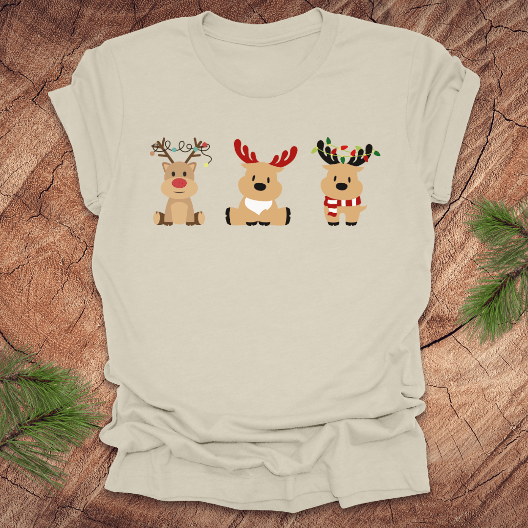 Beige t-shirt with cartoon reindeer design on a wooden surface