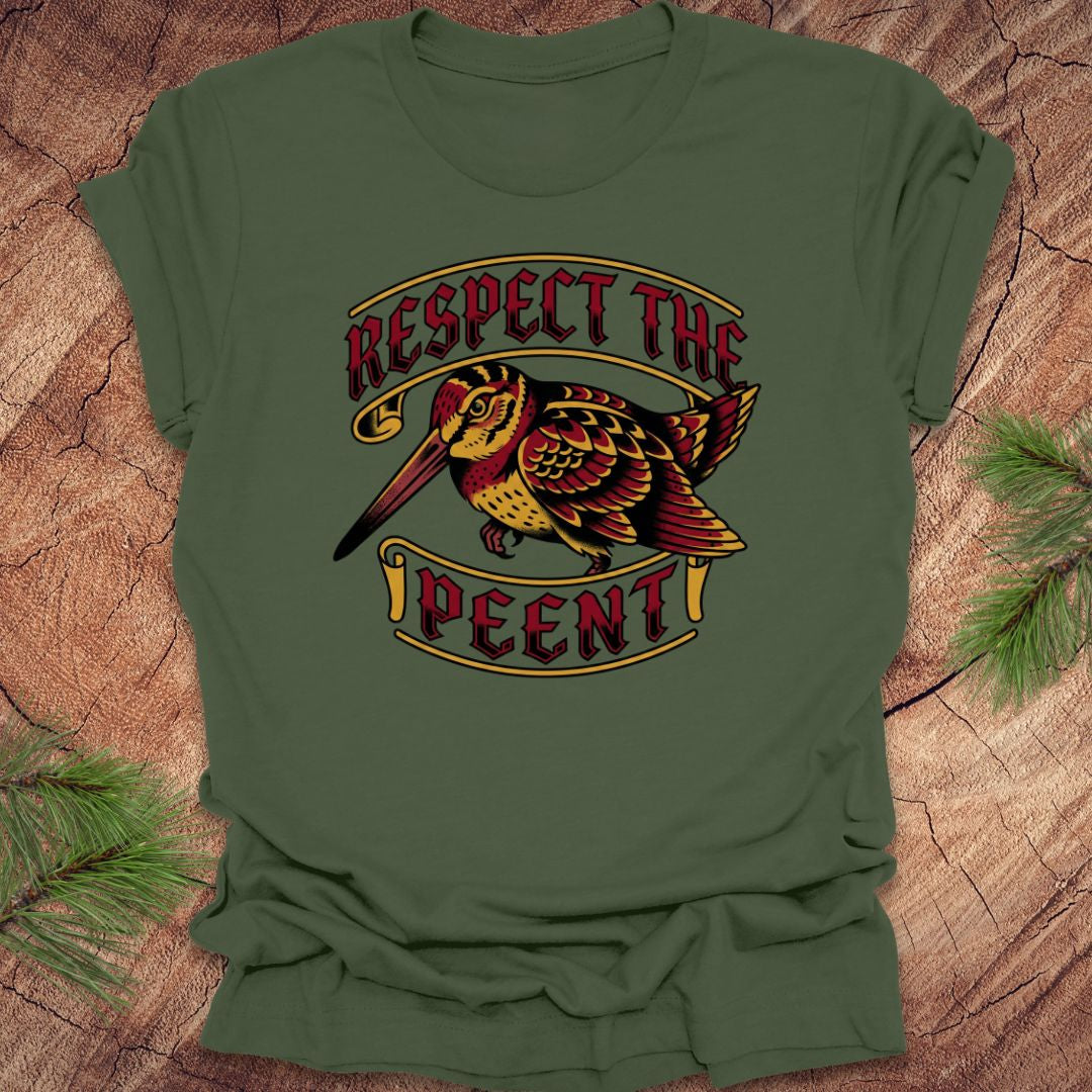 Green t-shirt with a bird graphic and 'Respect the Peent' text on a wooden surface.