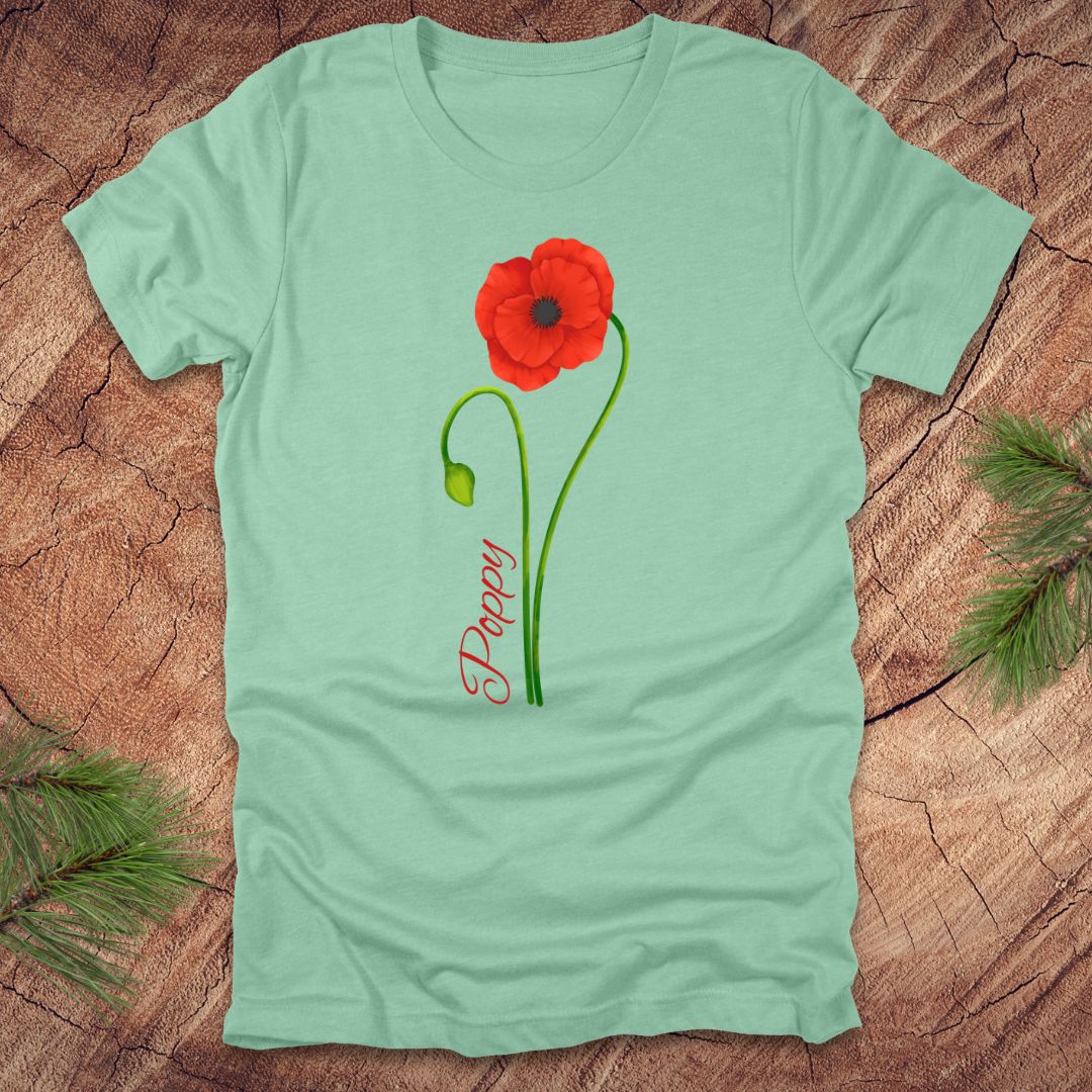 Light green t-shirt with a red poppy design on a wooden surface