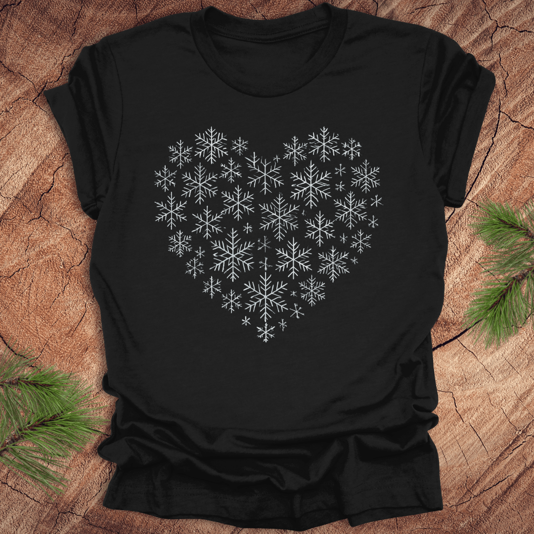 Black t-shirt with snowflakes making the shape of a heart on a wood background.