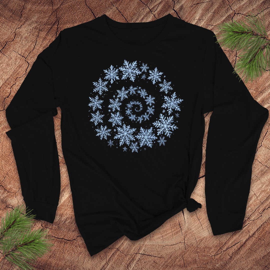 Black long sleeve shirt with a blue snowflake spiral design on a wooden surface with pine branches.